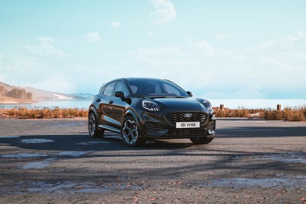 Une Ford Puma noire de l'édition Black & White sur une route côtière avec la mer en arrière-plan